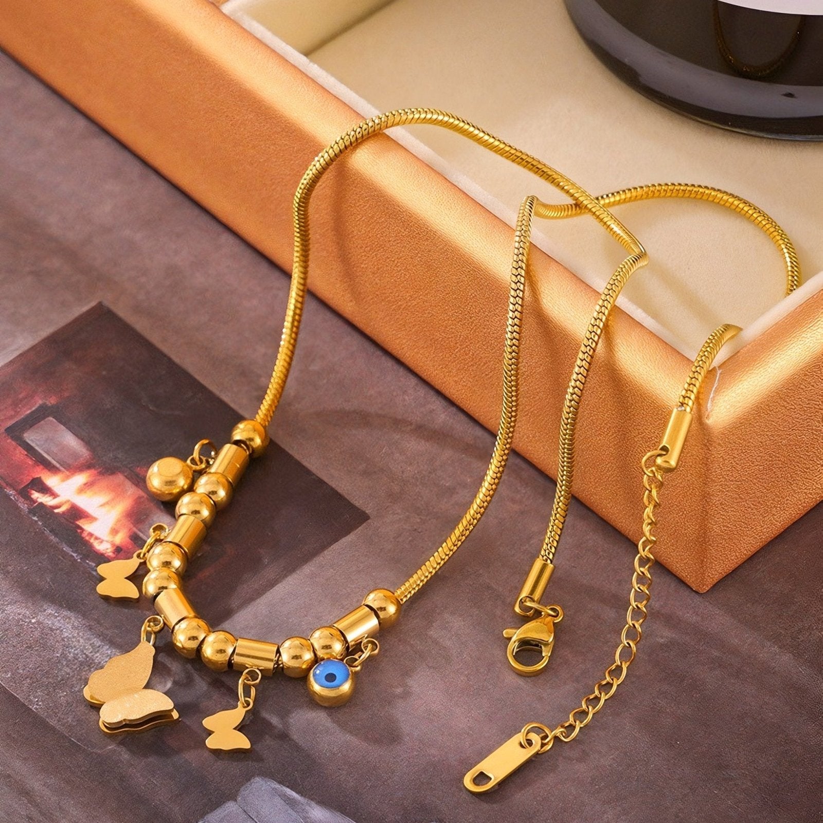 Collier ras du cou doré, style charms, pendentifs papillons et œil bleu, acier titane, modèle Angelina