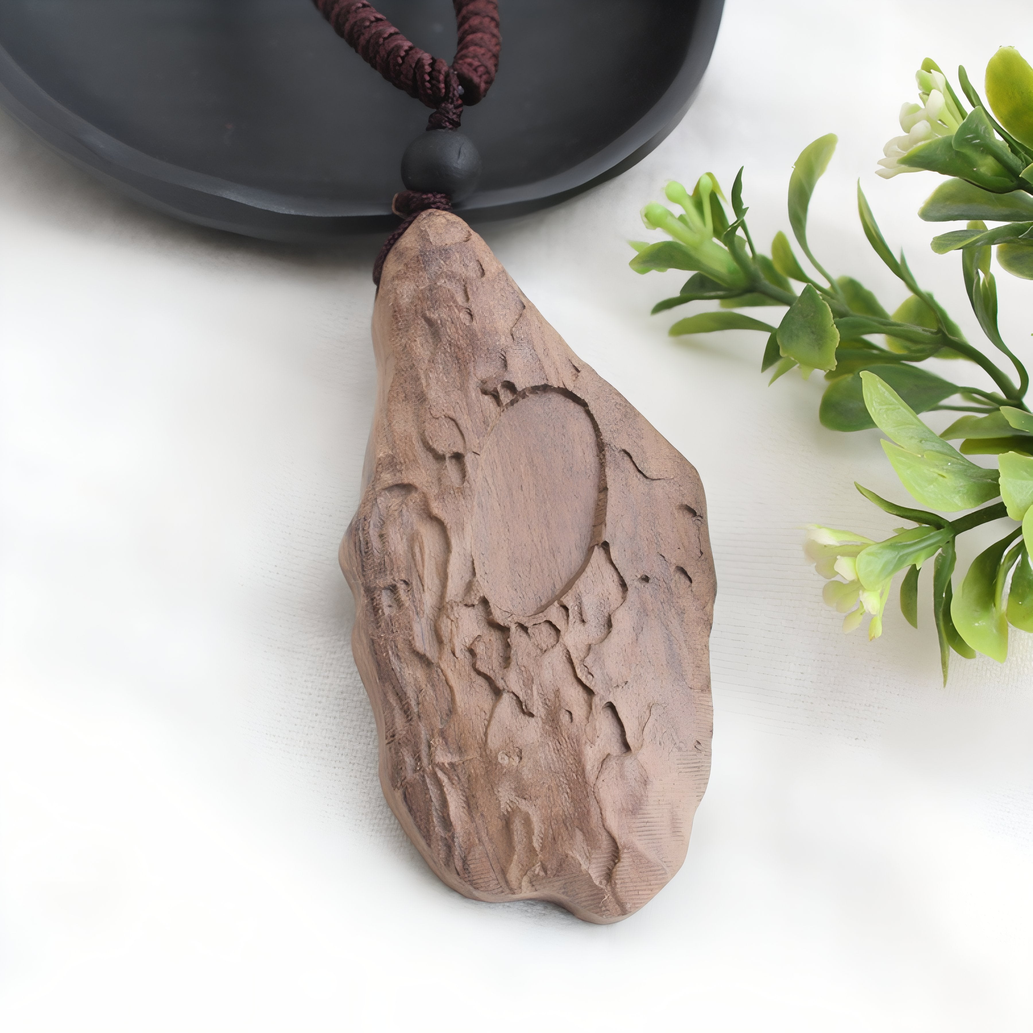 Geschnitzte Holzkette mit einem organisch geformten, blattförmigen Anhänger und einer Perle im Bohème-Stil