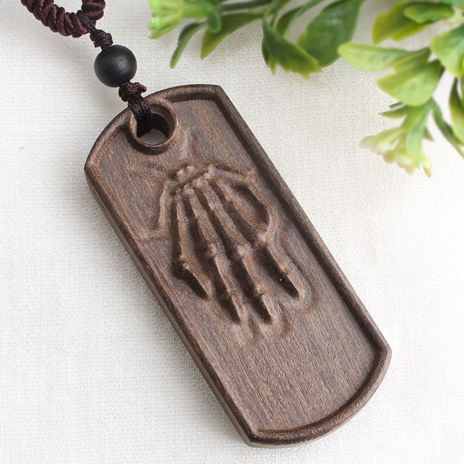 Collier artisanal en bois naturel sculpté, avec pendentif main ancestrale, style bohème