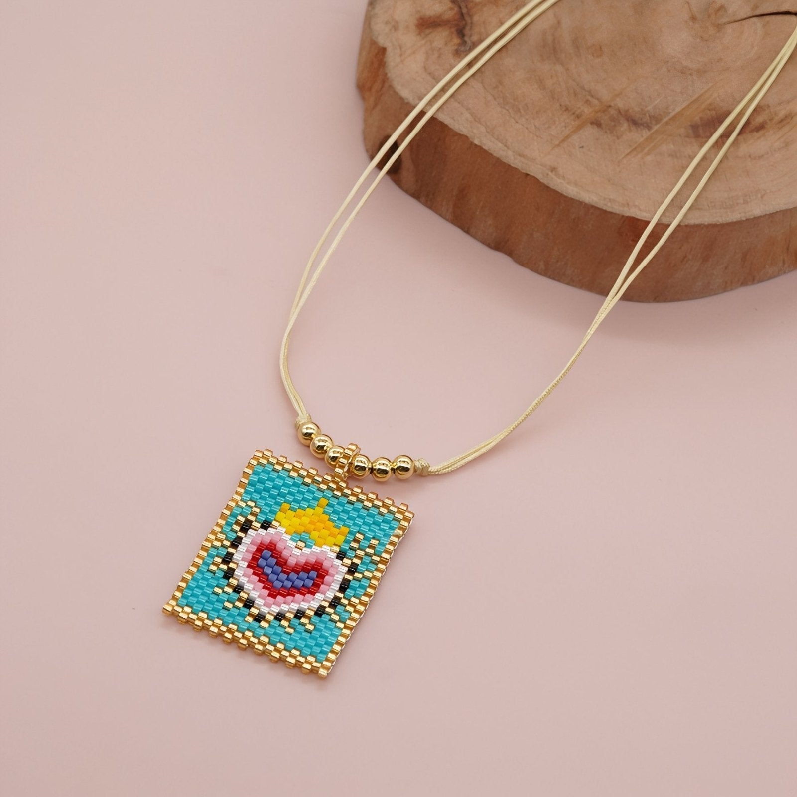 Collier artisanal multicolore en perles Miyuki, motif œil protecteur ou cœur sacré, cordon doré