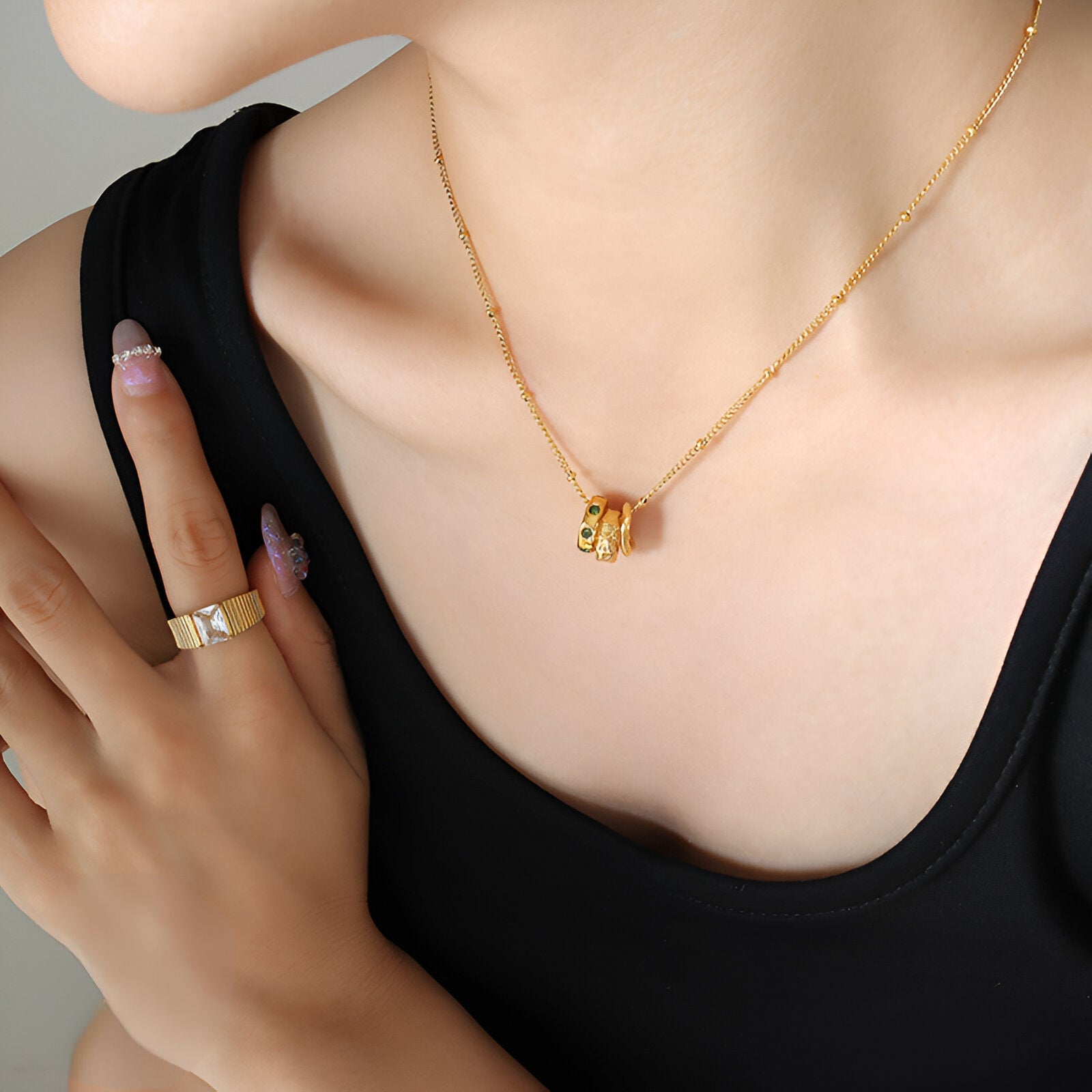Collier bijou doré trois anneaux entrelacés, strass verts, style contemporain féminin, modèle Yara