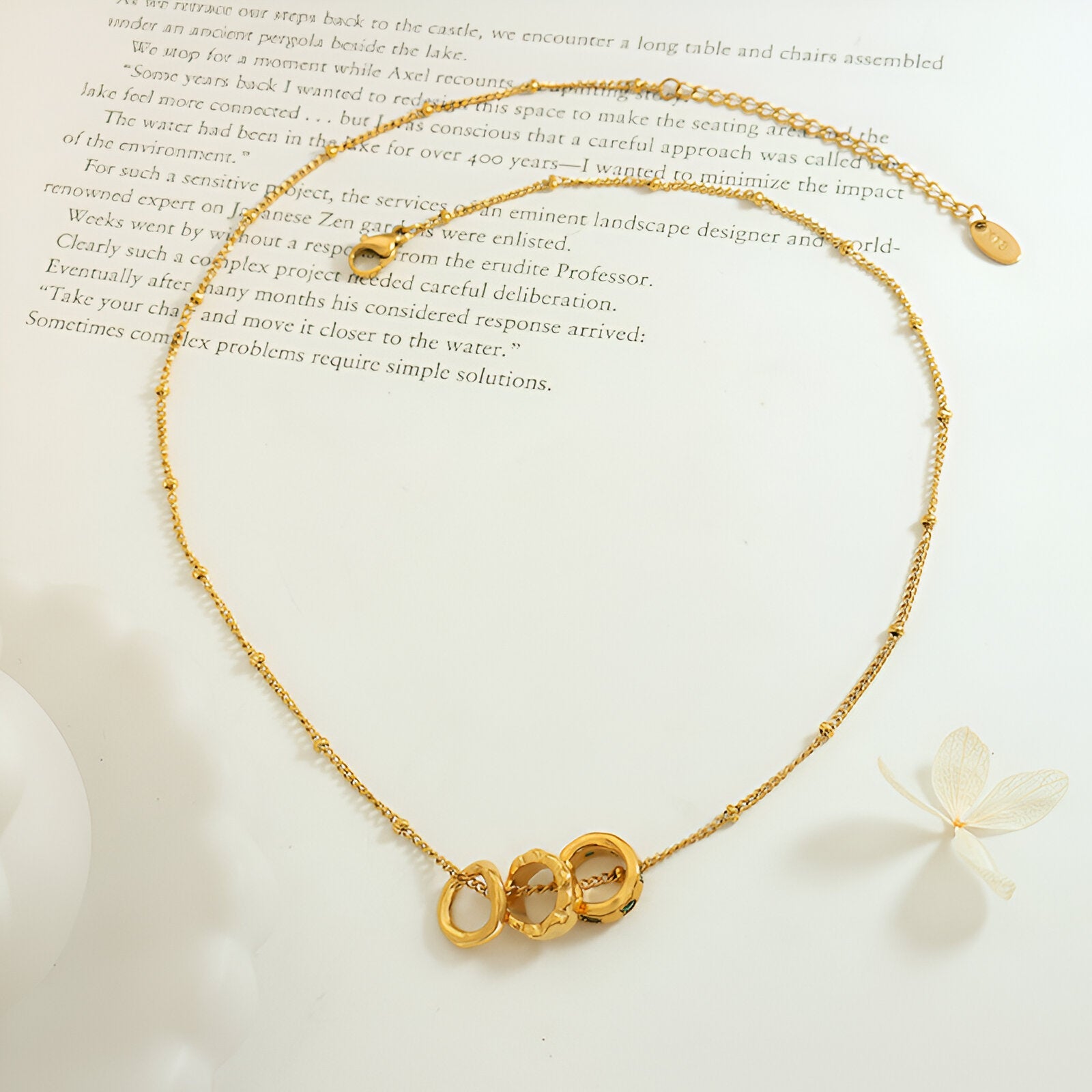 Collier bijou doré trois anneaux entrelacés, strass verts, style contemporain féminin, modèle Yara