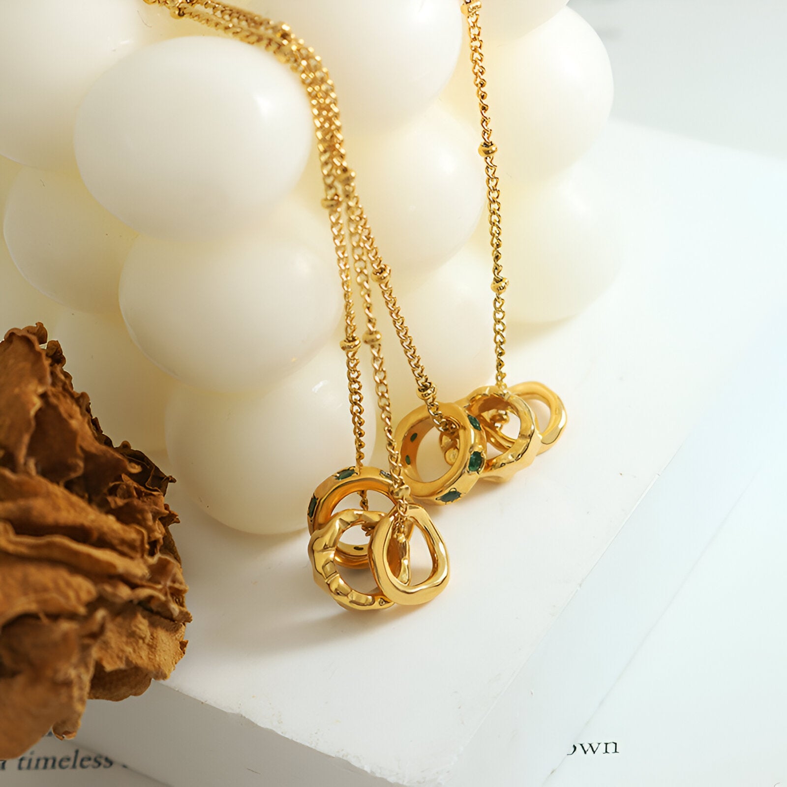 Collier bijou doré trois anneaux entrelacés, strass verts, style contemporain féminin, modèle Yara