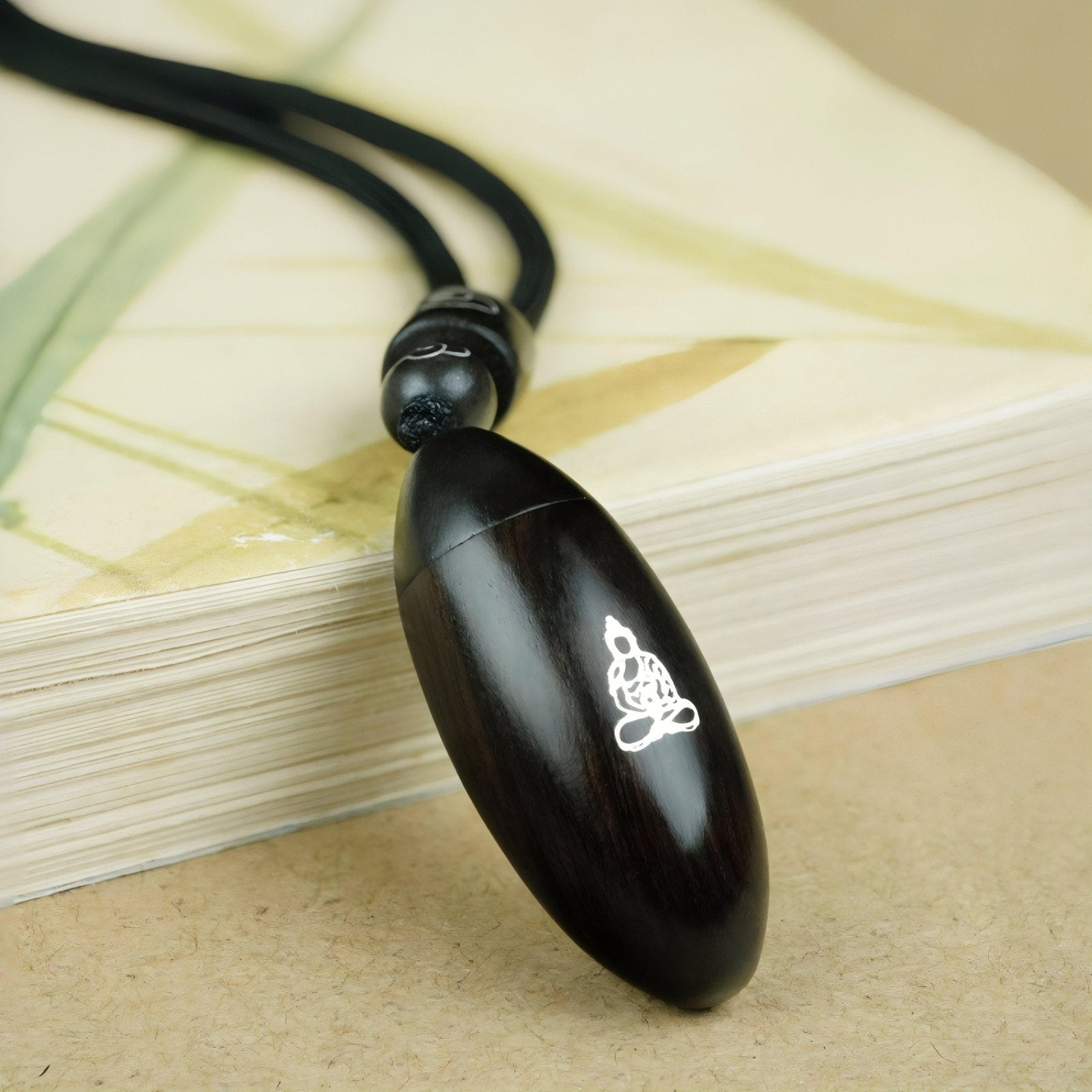 Collier en bois d'ébène naturel, avec pendentif ouvrant incrusté d'argent, cordon ajustable