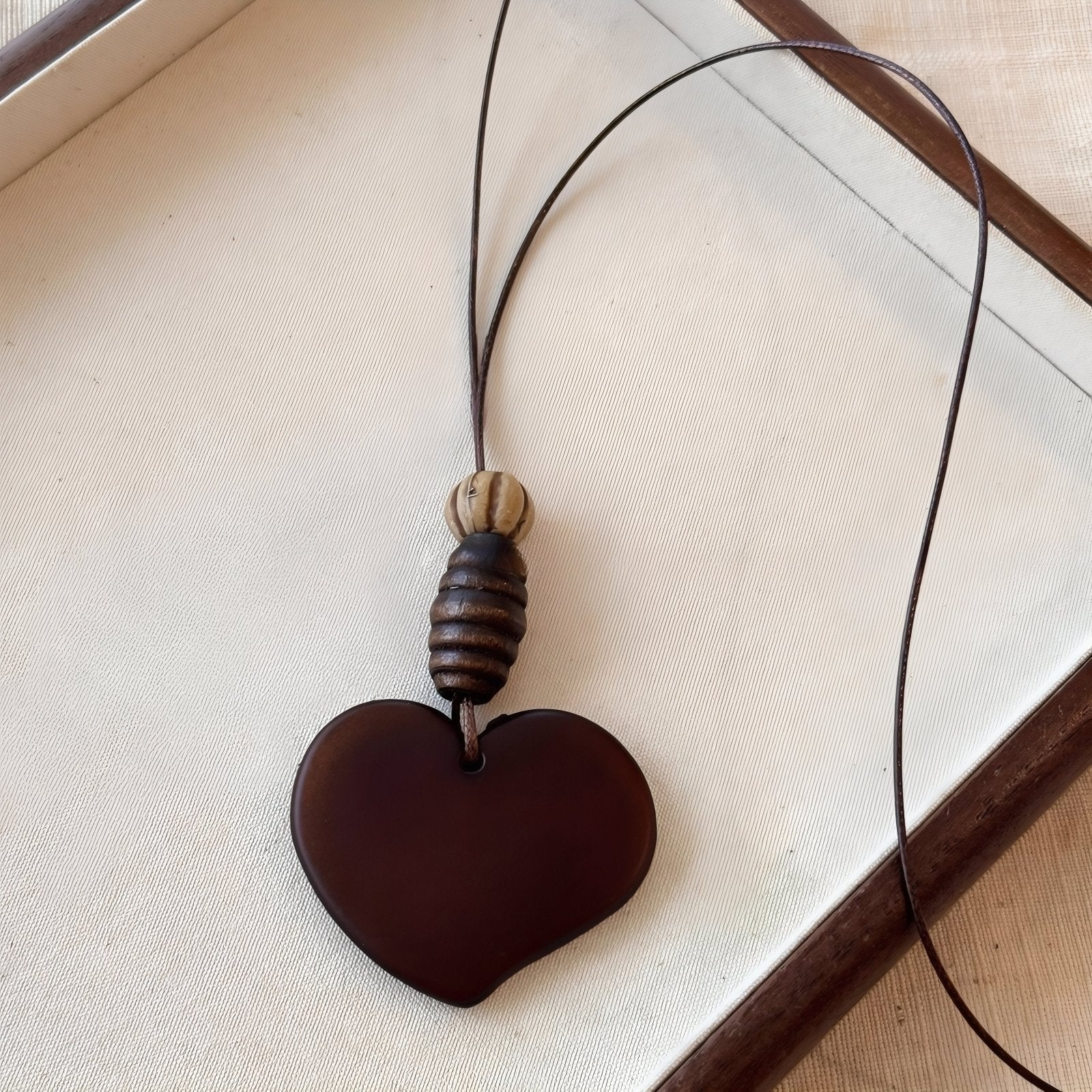 Collier en bois naturel, avec pendentif cœur surmonté de perles ethniques, cordon ajustable