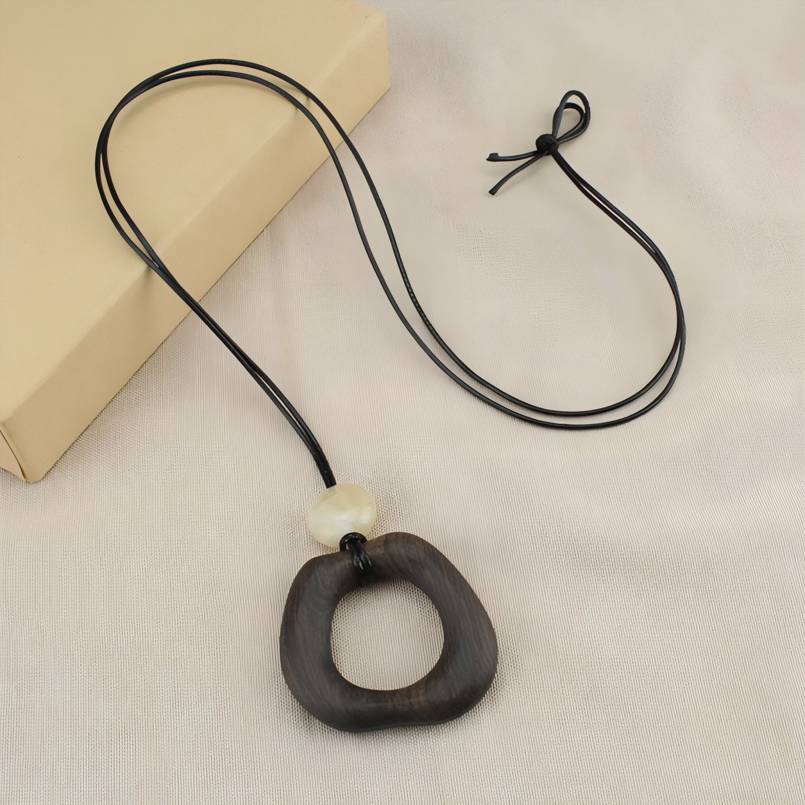 Collier en bois naturel, avec pendentif géométrique ajouré et perle blanche, cordon noir