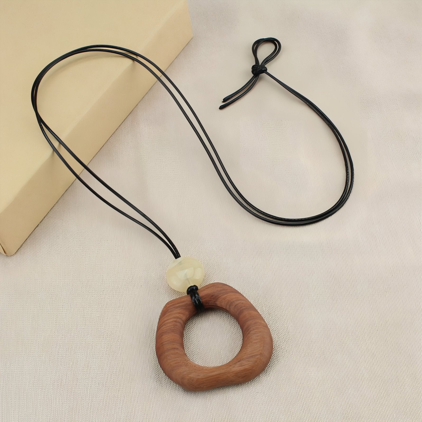 Collier en bois naturel, avec pendentif géométrique ajouré et perle blanche, cordon noir