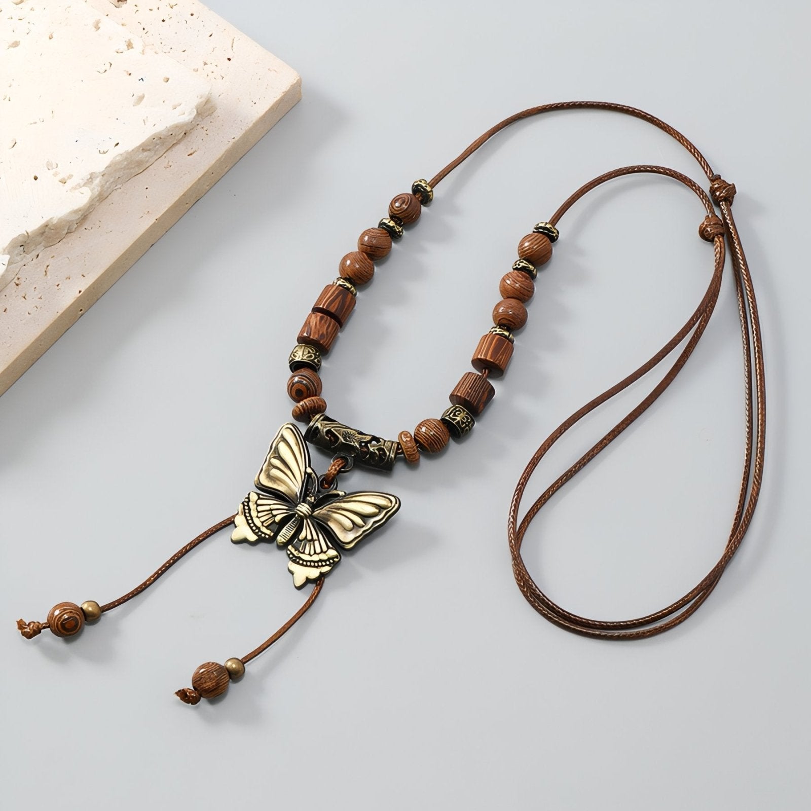 Collier long bohème, pendentif papillon en métal vieilli et perles en bois, style ethnique chic