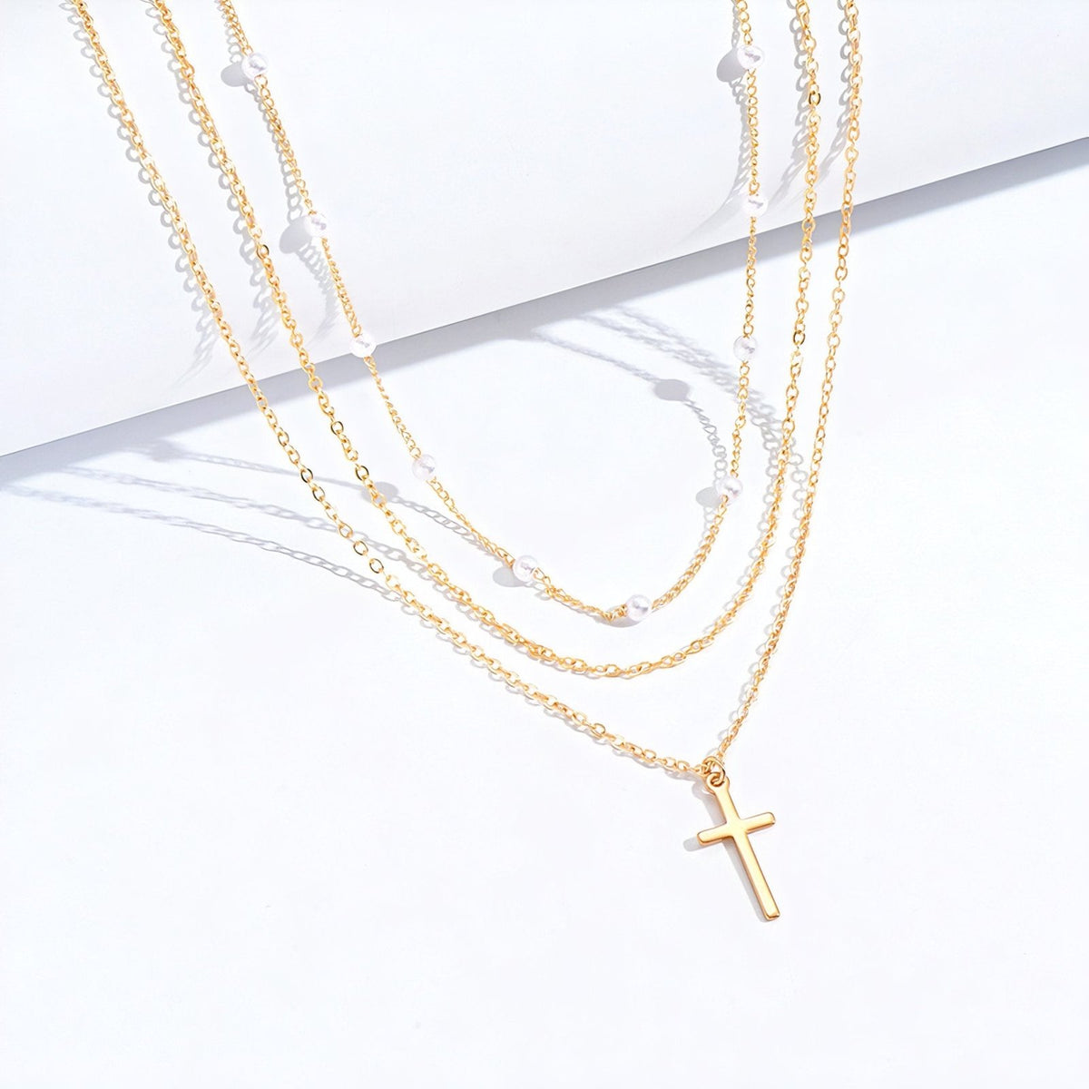 Collier multi-rangs avec pendentif croix et perles blanches