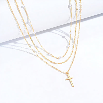 Collier multi-rangs avec pendentif croix et perles blanches