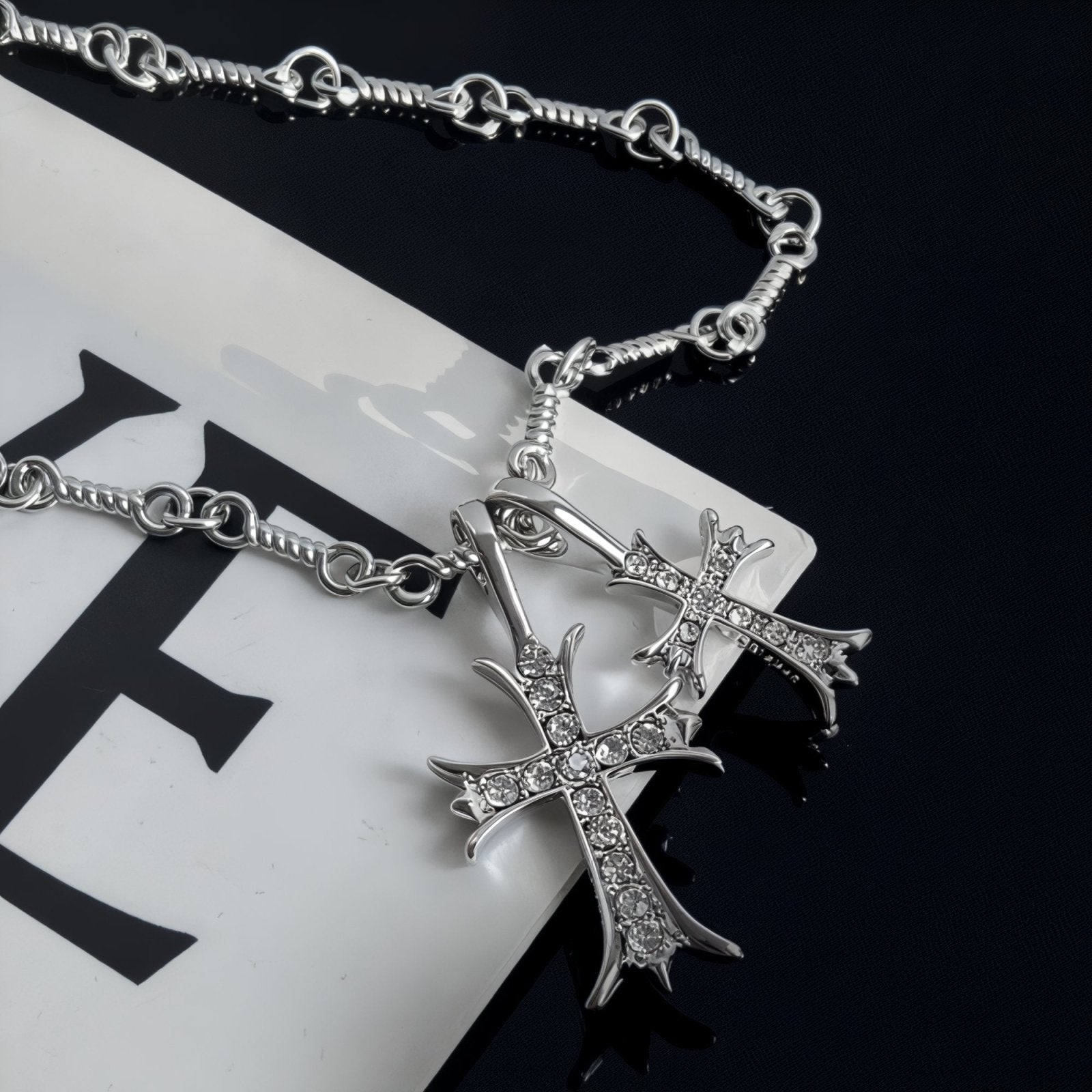 Collier pendentif croix superposées, en métal argenté, serti de zircons, modèle Raven