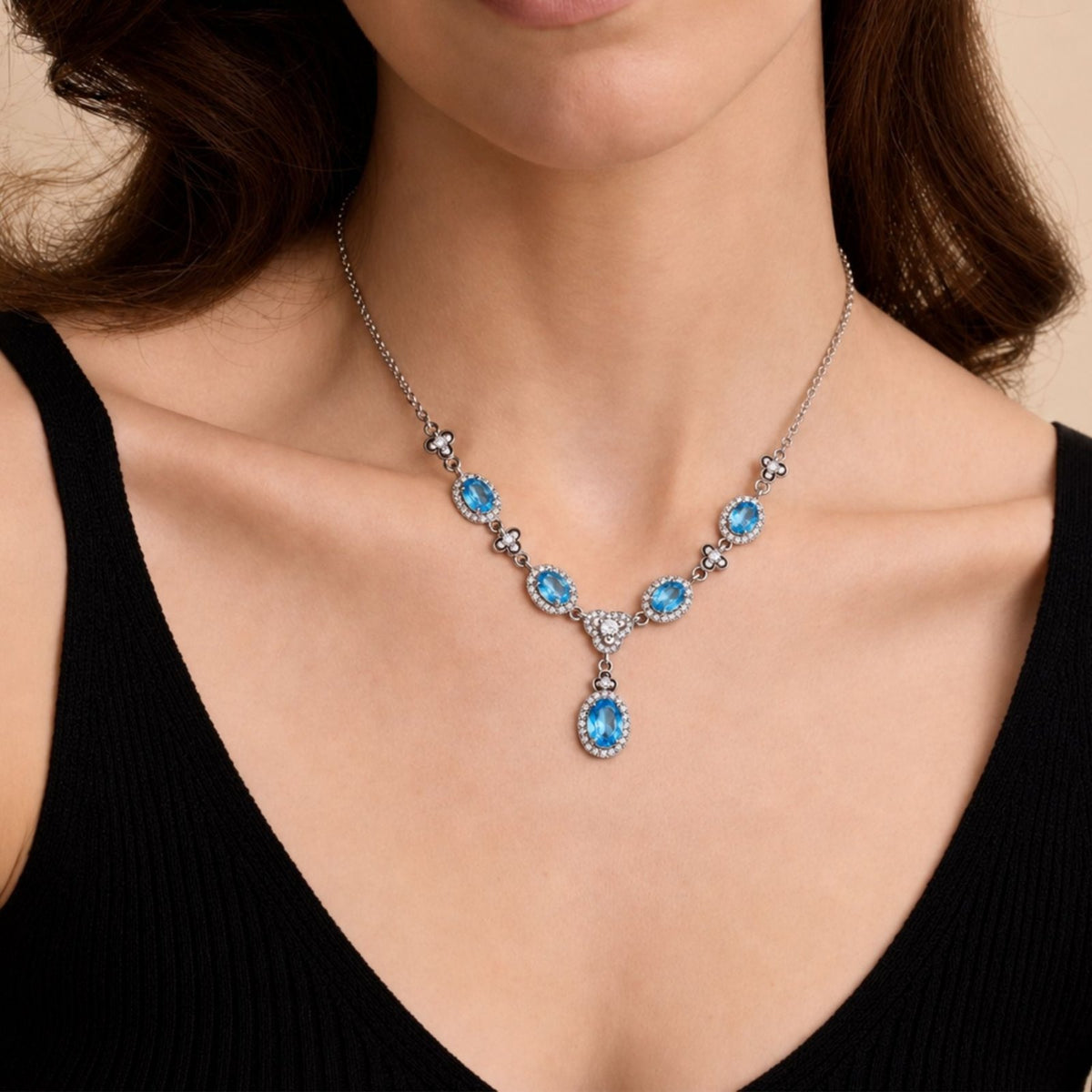 Collier pierres ovales pour femme en métal argenté, pendentif central avec pierres effet topaze bleue, rubis ou émeraude entourées de pierres blanches