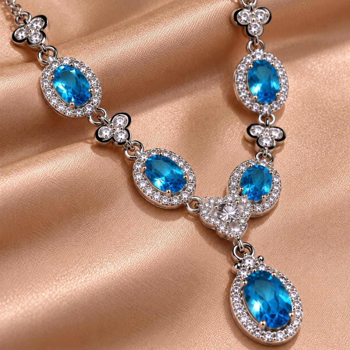Collier pierres ovales pour femme en métal argenté, pendentif central avec pierres effet topaze bleue, rubis ou émeraude entourées de pierres blanches