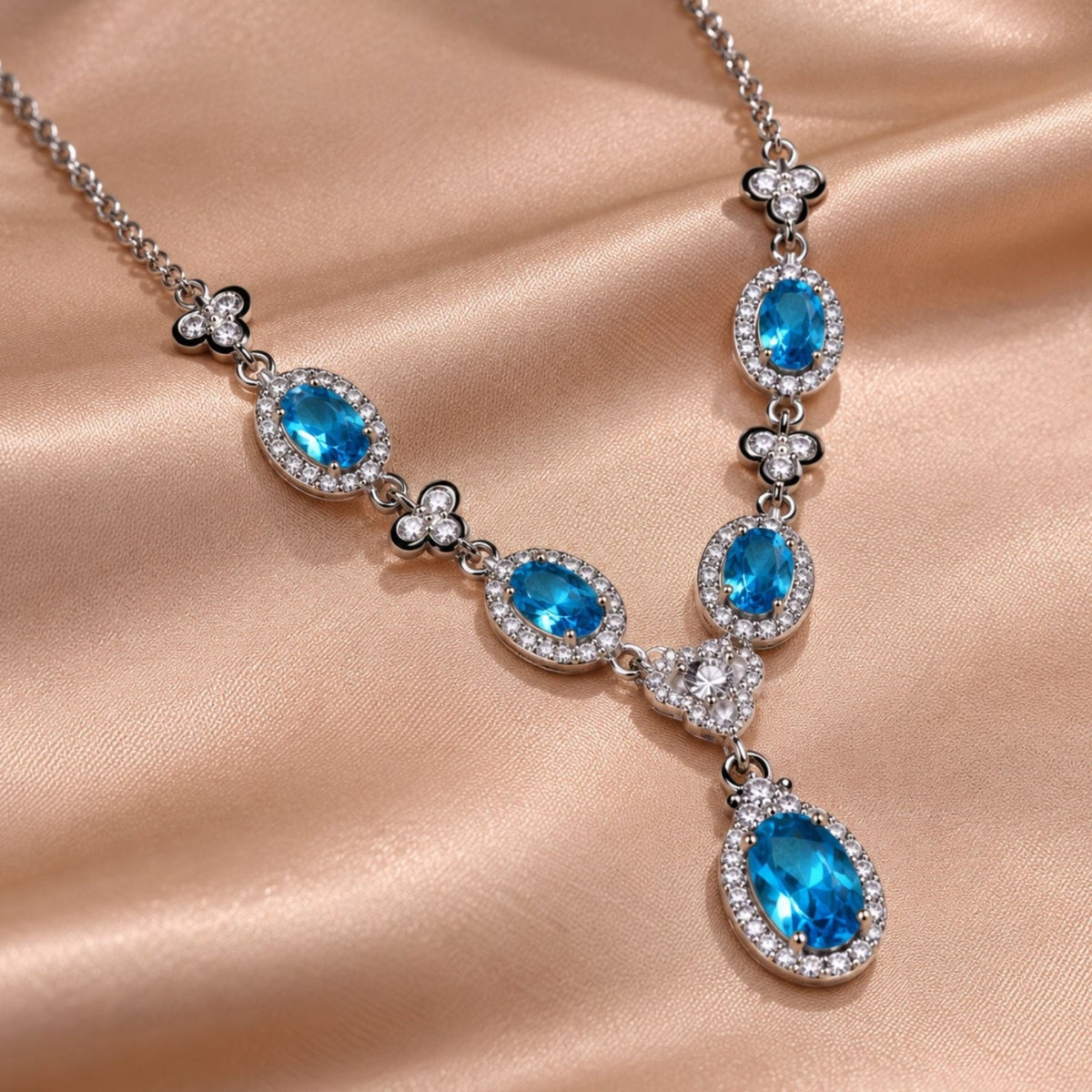 Collier pierres ovales pour femme en métal argenté, pendentif central avec pierres effet topaze bleue, rubis ou émeraude entourées de pierres blanches