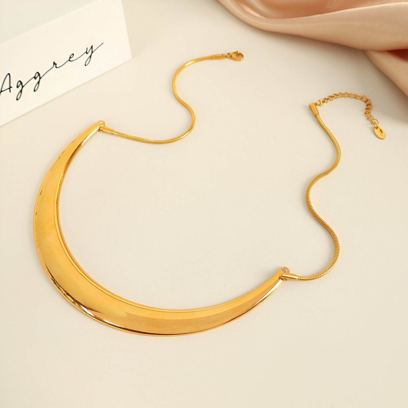 Collier plastron rigide pour femme, design incurvé doré ou argenté, style sculptural et moderne, modèle Alma
