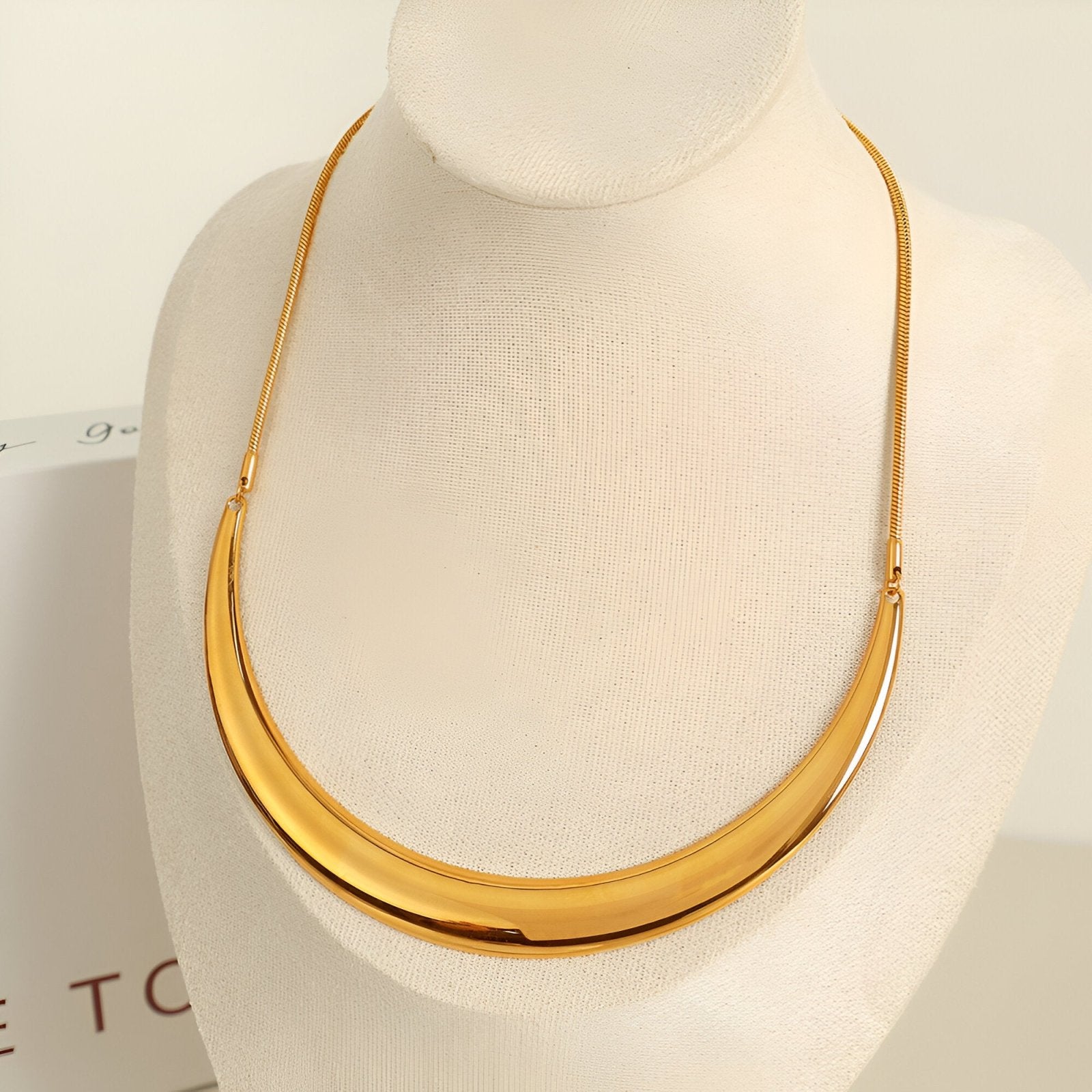 Collier plastron rigide pour femme, design incurvé doré ou argenté, style sculptural et moderne, modèle Alma