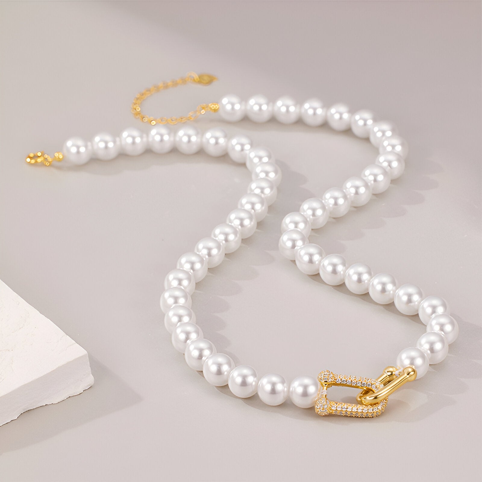 Collier ras - du - cou perles nacrées, fermoir design en U serti, look minimaliste et sophistiqué, modèle Eva