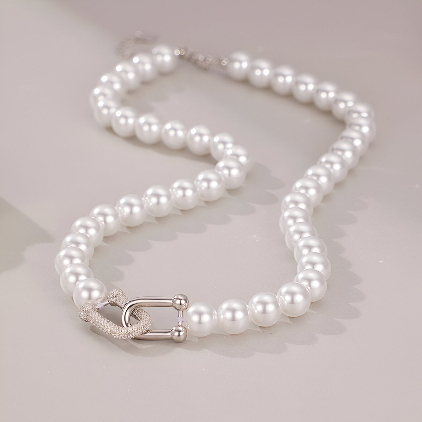 Collier ras - du - cou perles nacrées, fermoir design en U serti, look minimaliste et sophistiqué, modèle Eva